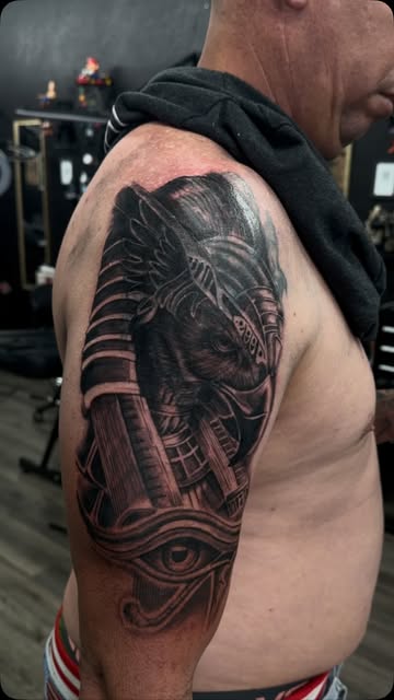 Black and grey Horus half sleeve tattoo seen in full on the shoulder